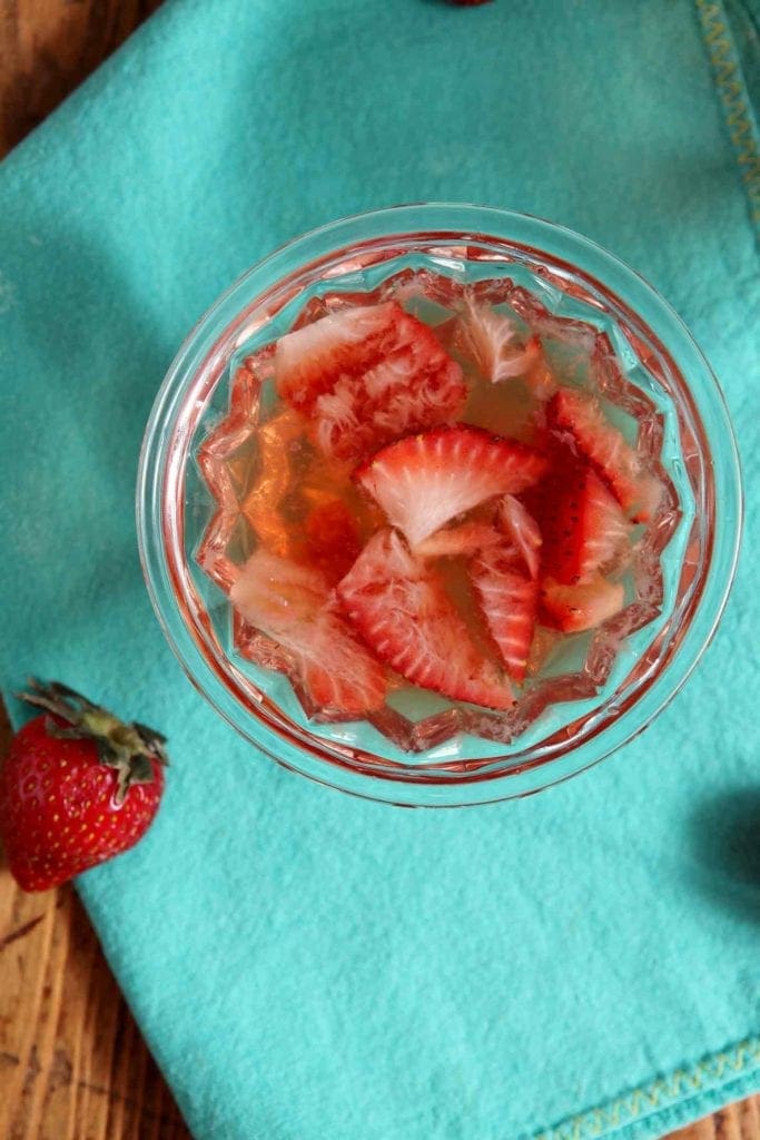 Overhead view of old fashioned in a glass with sliced strawberries