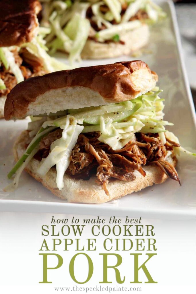 Three pulled pork sandwiches with apple slaw on a white platter with the text 'how to make the best slow cooker apple cider pork'