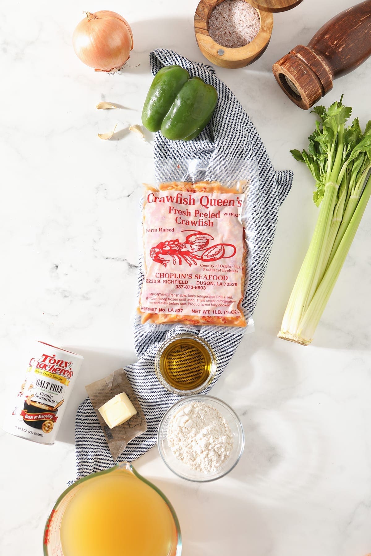 Ingredients for crawfish etouffee on a striped blue towel and marble