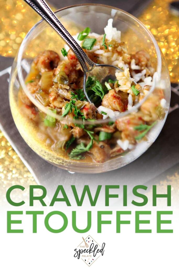 Close up of a glass holding crawfish etouffee and a spoon with the text "crawfish etouffee"