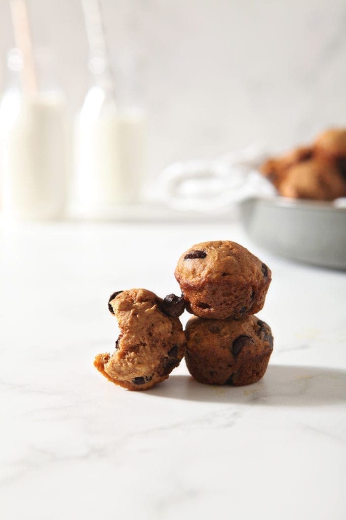 Muffins are stacked on top of each other, one with a bite out of it