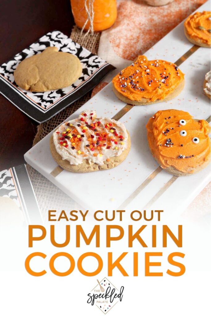 Decorated Pumpkin Sugar Cookies sit on a marble slab next to an undecorated cookie and jars of icing with the text 'easy cut out pumpkin cookies'