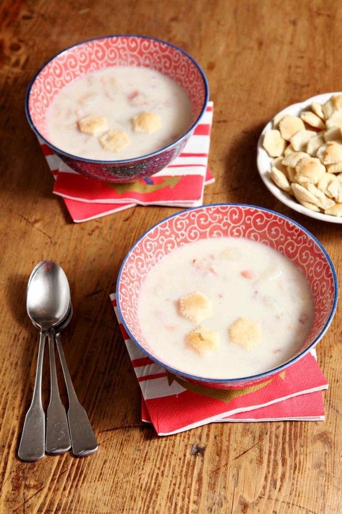 Two bowls of Bob's Bacon Potato Clam Chowder on wood table 