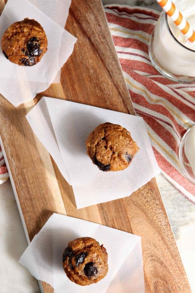 Mini Pumpkin Chip Muffins on a wooden board with milk from above