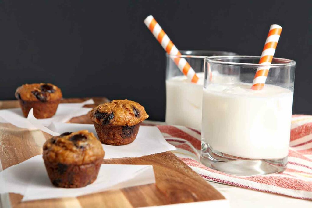 Mini Pumpkin Chip Muffins on a wooden board with milk