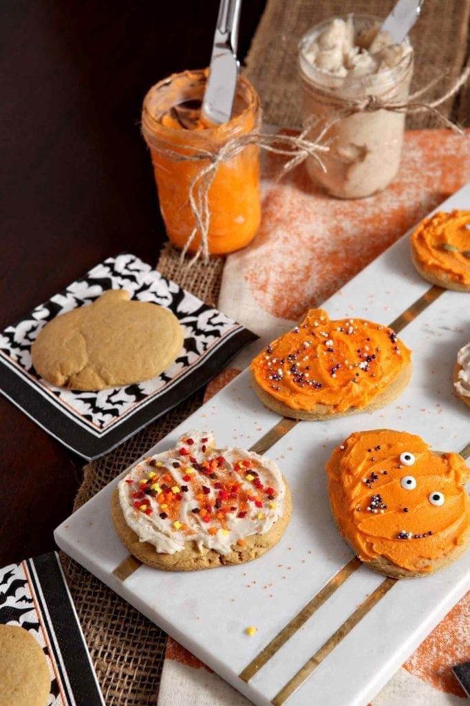 A marble platter holds several decorated Spiced Pumpkin Sugar Cookies