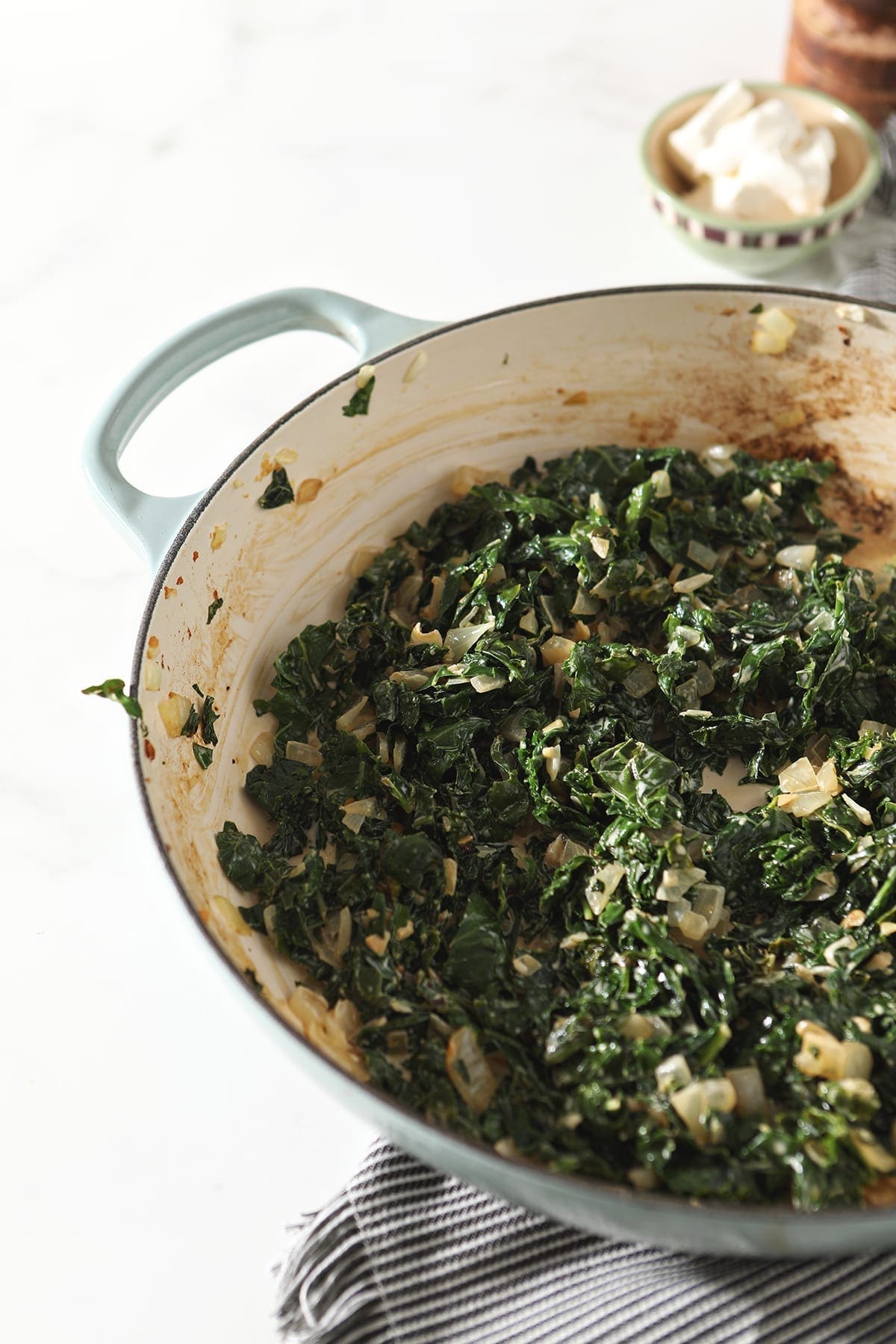 Kale with cream in a pan, before cream cheese is added