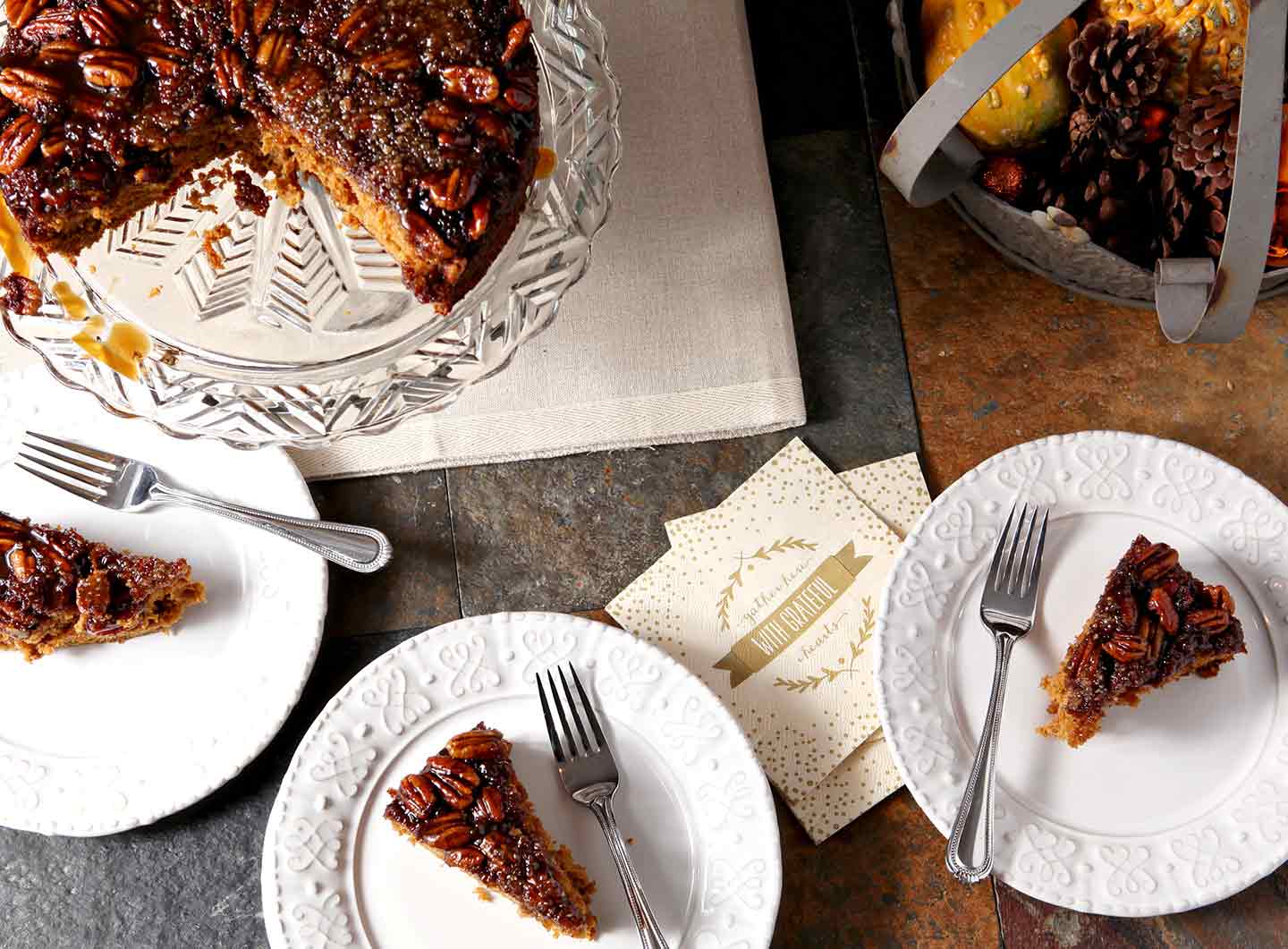 Three slices of Praline Pumpkin Upside Down Cake are served on a dark background