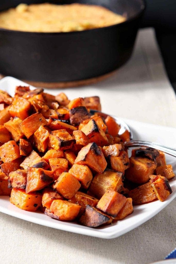 Close up of Bourbon Butter Sweet Potatoes on a white platter