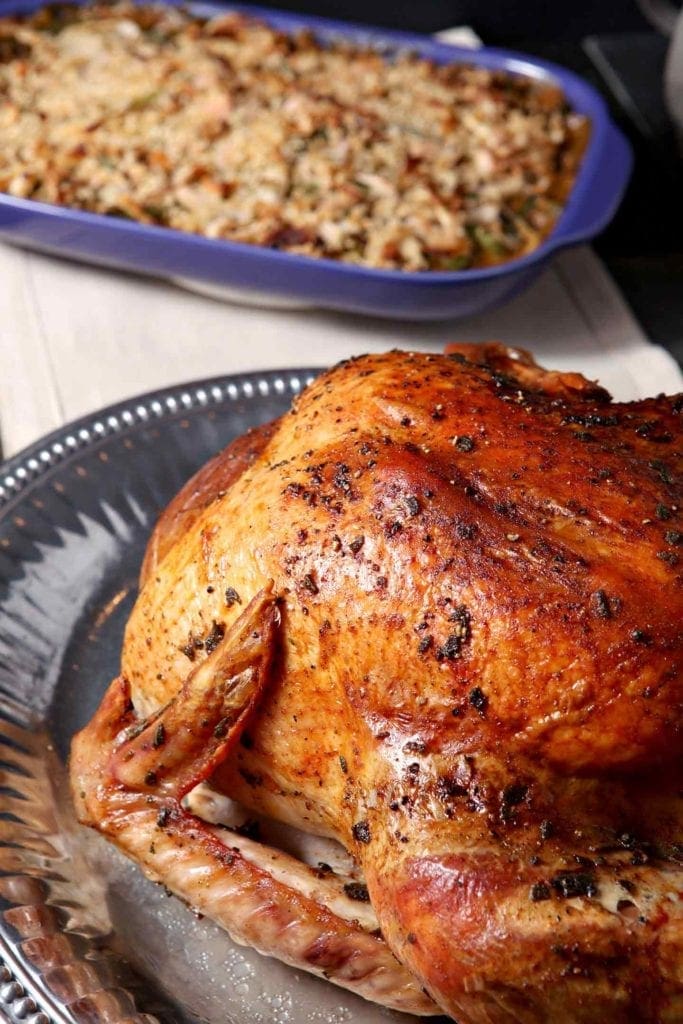 A golden brown turkey on a table before carving