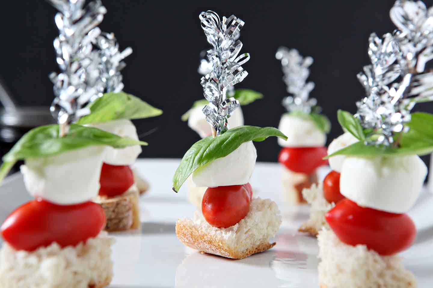 close up of caprese skewers on a white plate