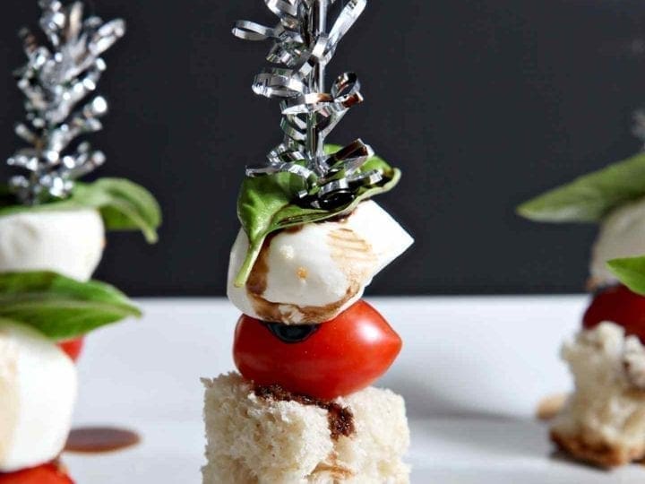 close up of caprese skewers on a white plate