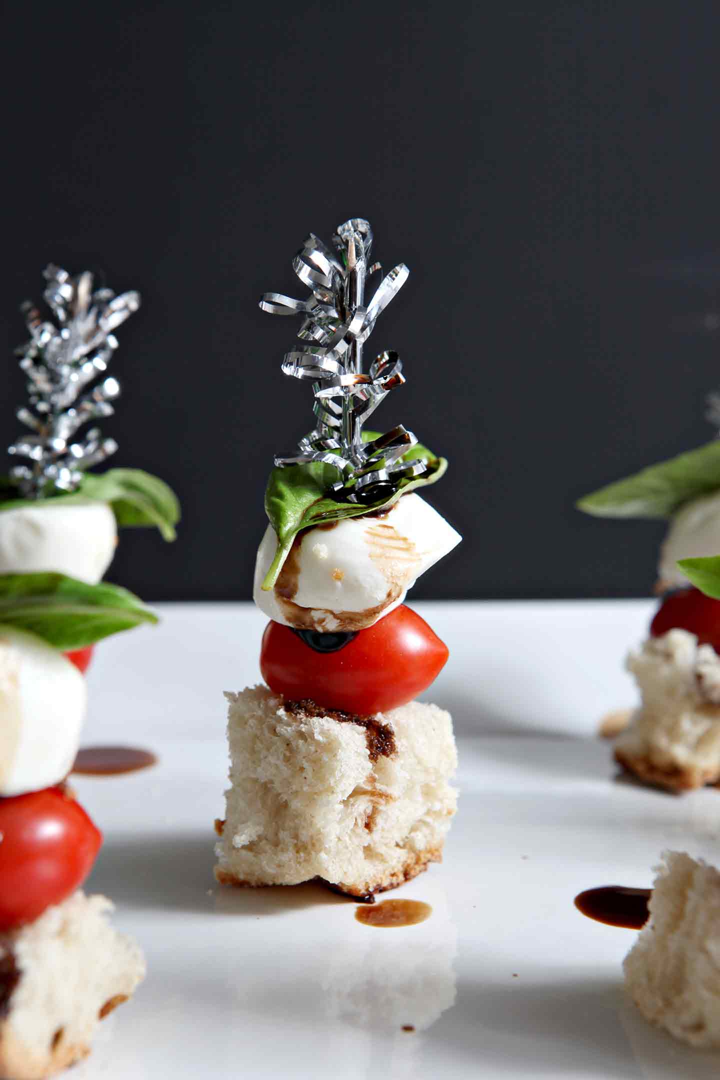 close up of caprese skewers on a white plate