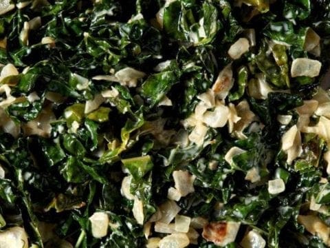 Close up of cooked creamy kale in a skillet from above