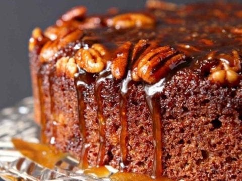 The topping drips down the side of a Praline Pumpkin Upside Down Cake before serving