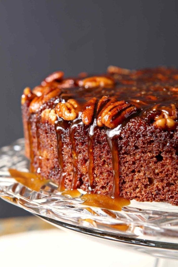 The topping drips down the side of a Praline Pumpkin Upside Down Cake before serving