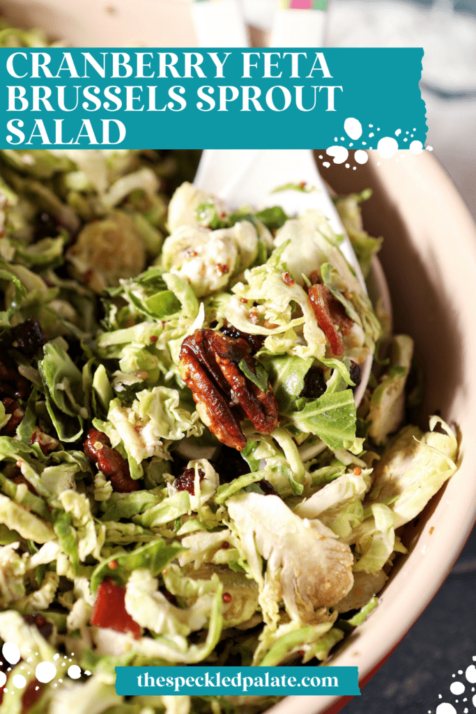 Close up of salad tongs in a bowl with a Cranberry Feta Brussels Sprout Salad with the text cranberry feta brussels sprout salad