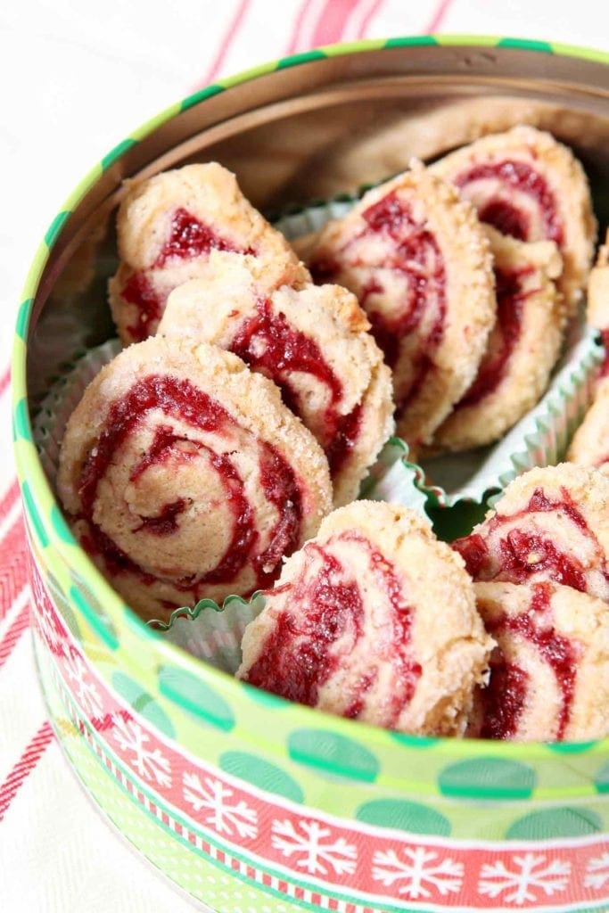 cranberry pinwheel cookies in a holiday tin