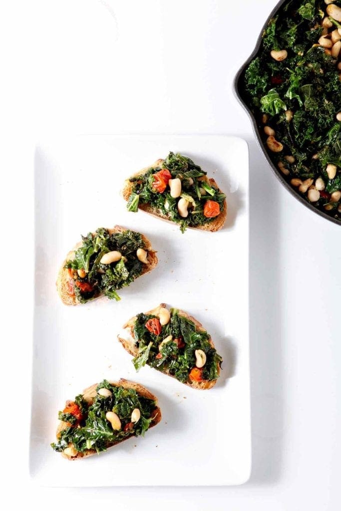 tuscan kale bruschetta on a white plate