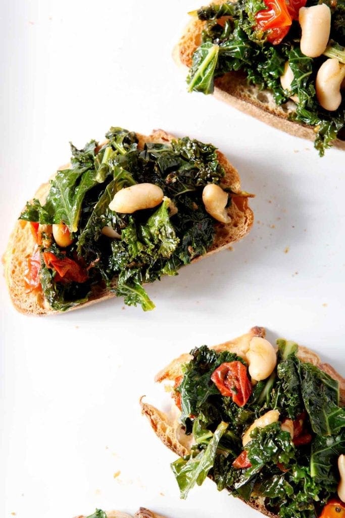 tuscan kale bruschetta on a white plate