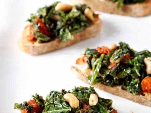 tuscan kale bruschetta on a white surface