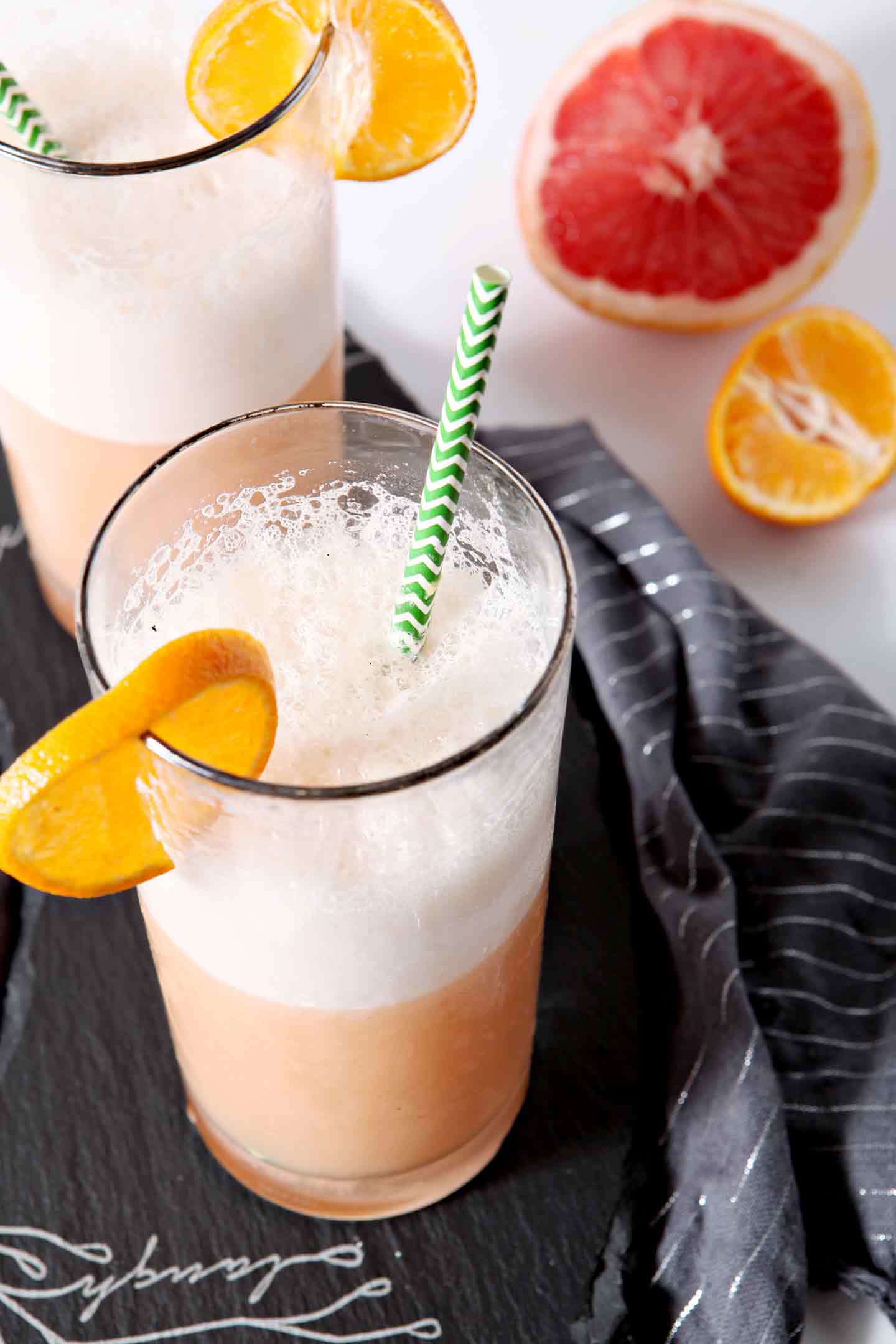 winter citrus smoothie in a glass with a green straw