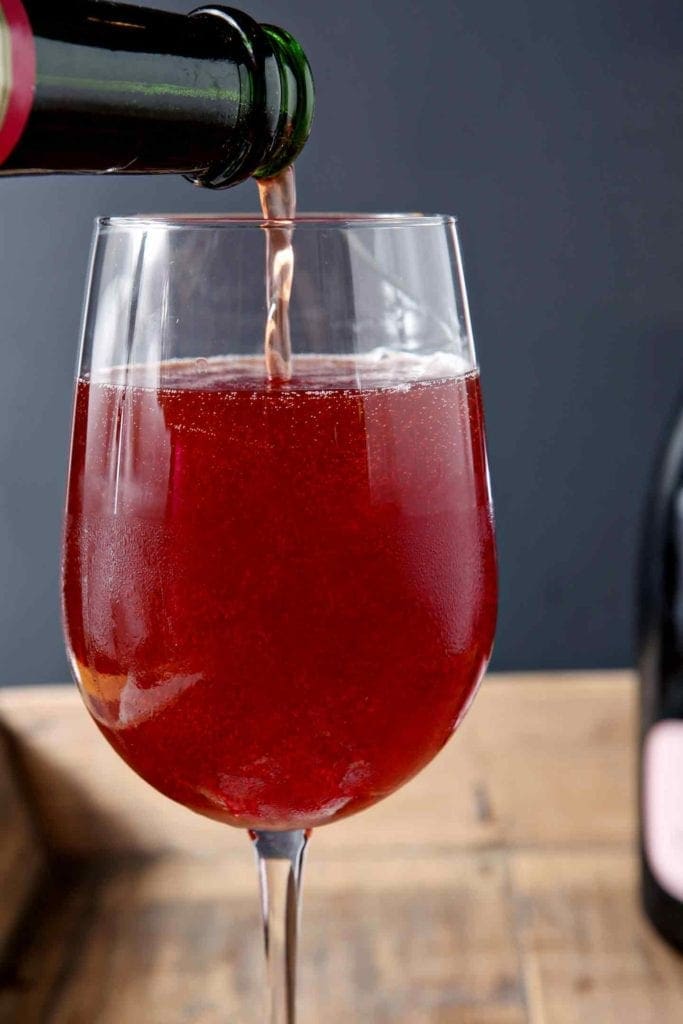 Framboise Lambic is poured on top of champagne to make a Framboise Champagne Cocktail