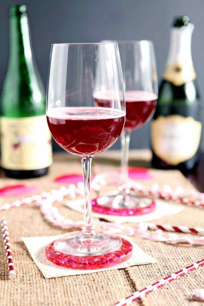 Two Framboise Champagne Cocktail are served on a decorate tabletop