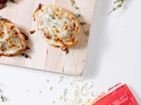 Pieces of Bruschetta on wood board and package of cheese