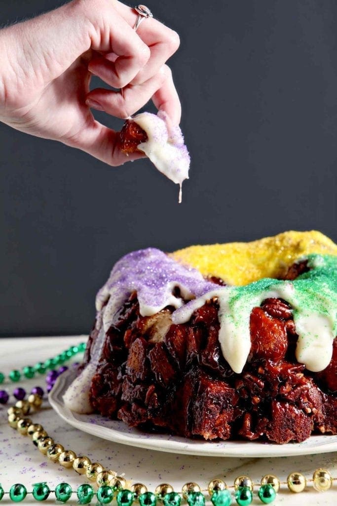 A woman pulls a piece of monkey bread off of the final decorated baked good