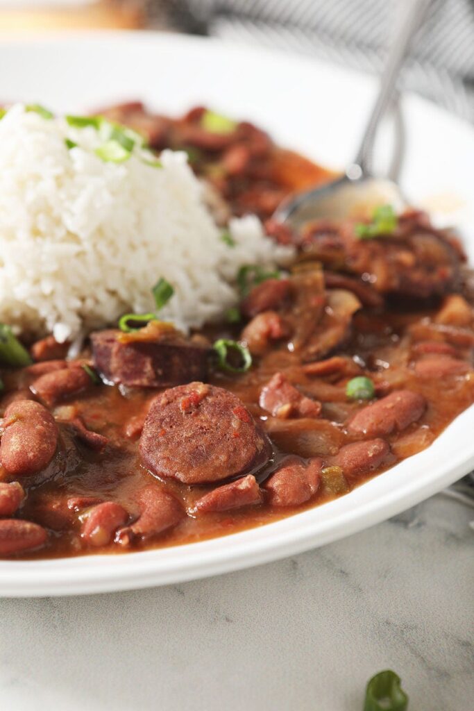 Sliced andouille sausage and red beans in a bowl with rice