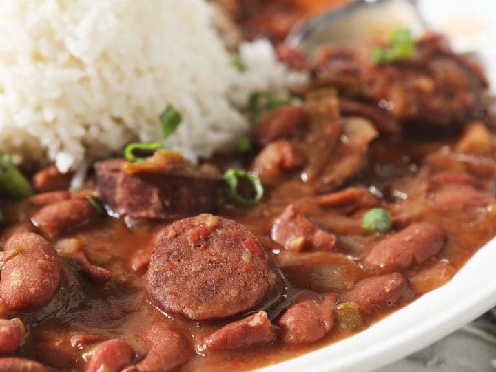 Sliced andouille sausage and red beans in a bowl with rice