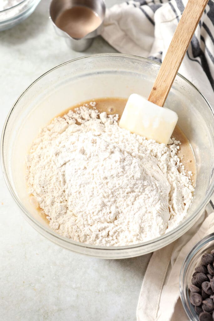 Dry ingredients on top of wet ingredients in a bowl with a rubber spatula before mixing