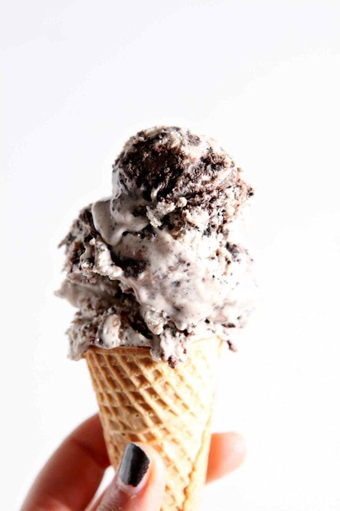 A person holds a cone of No Churn Brownie Ice Cream