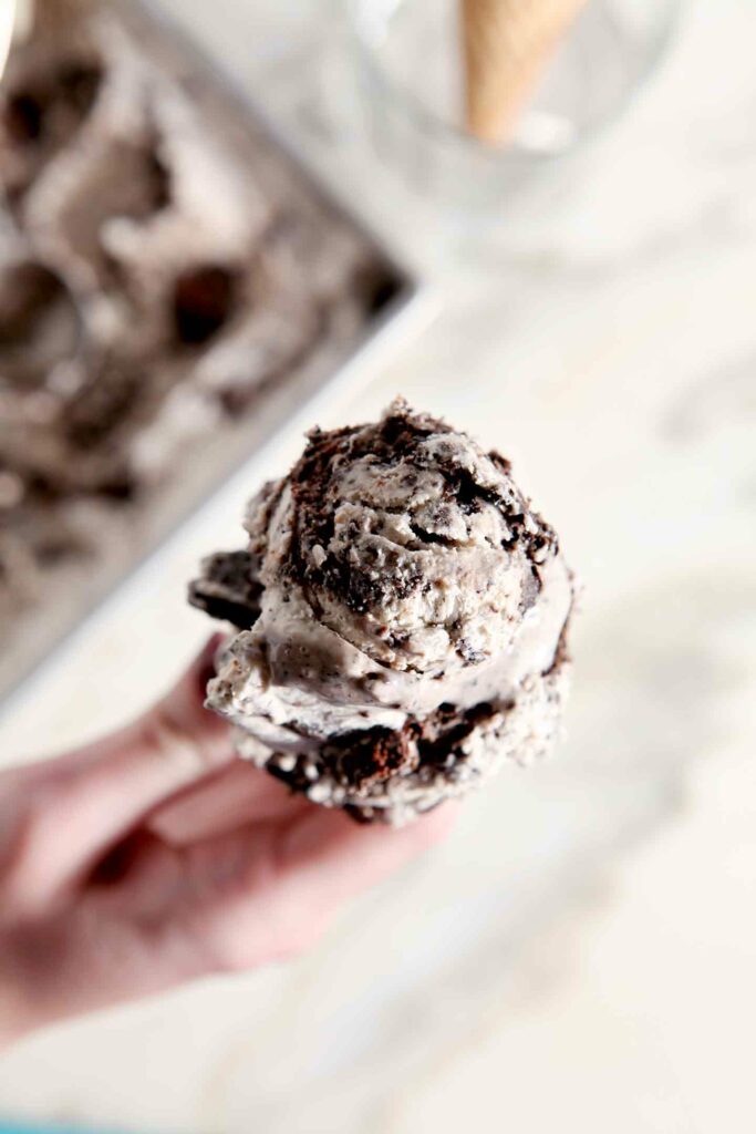 A woman holds a cone of No Churn Guinness Brownie Ice Cream