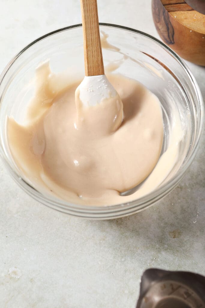 Irish cream icing in a bowl with a small rubber spatula