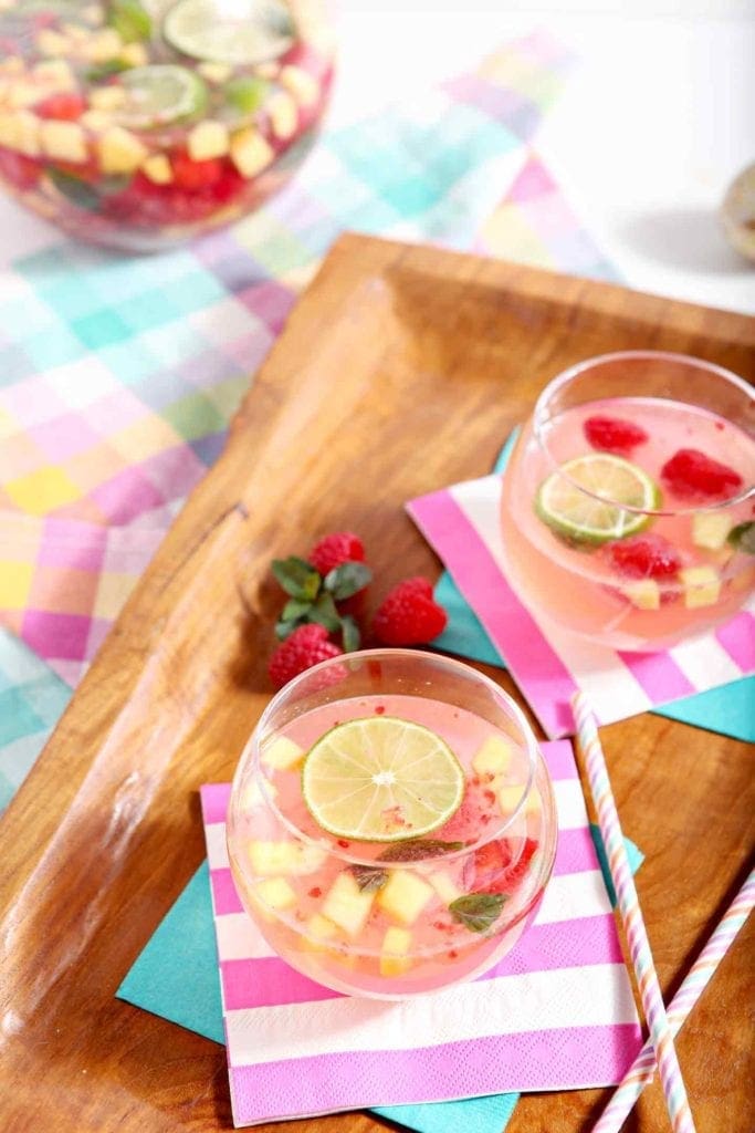 Two glasses of homemade sangria on colorful napkins on a wooden tray