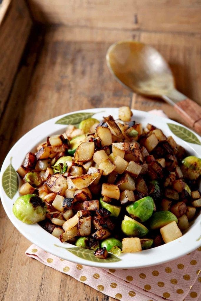 A bowl holds the winter vegetable hash, with a spoon for serving