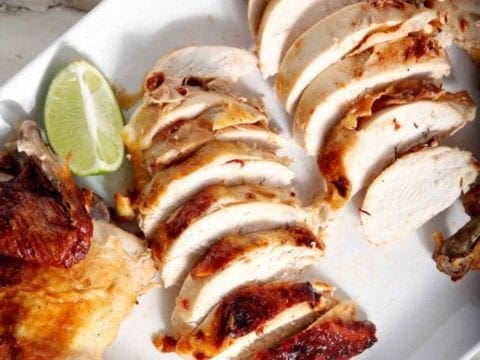 sliced beer can chicken on a white plate