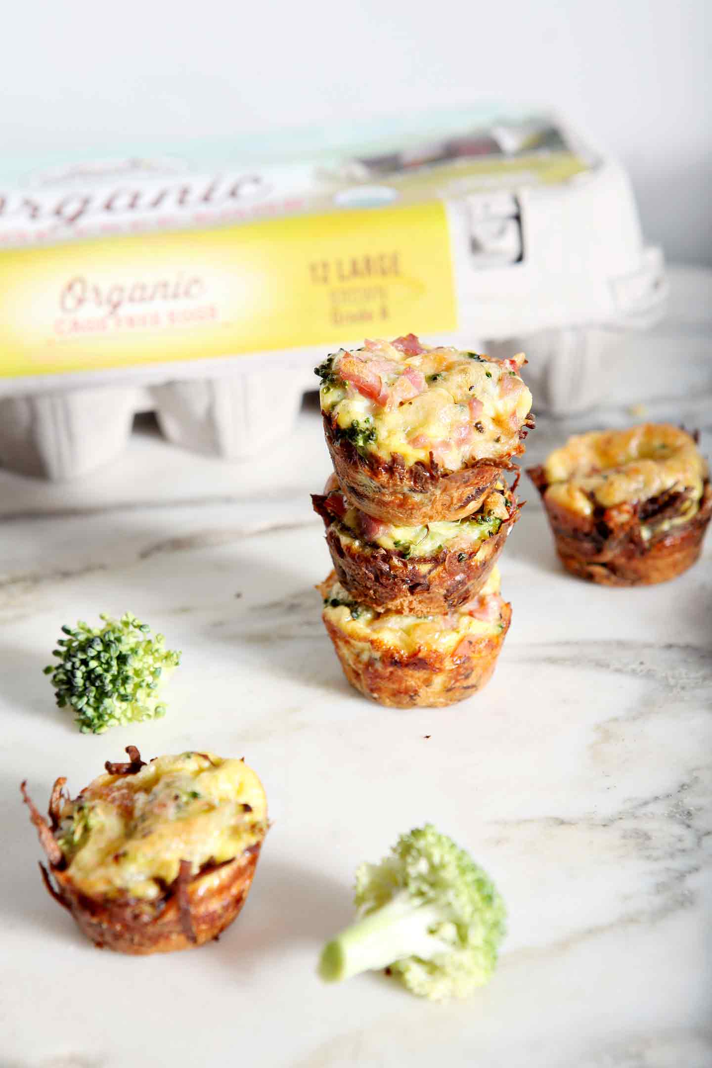 quiche bites stacked with egg carton behind