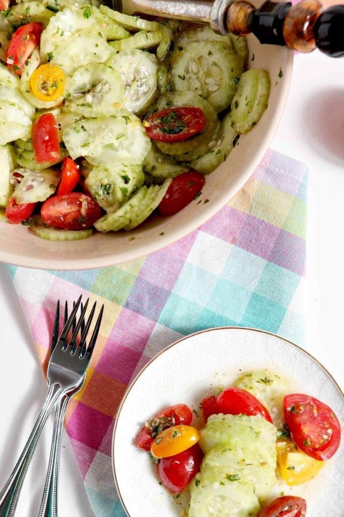 mediterranean salad on a white plate and in a large bowl