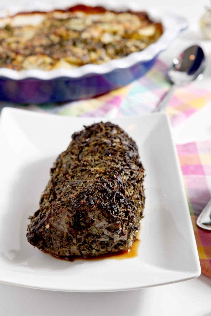 herb crusted beef tenderloin on a white plate