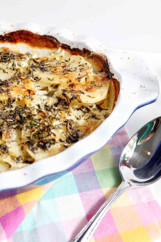 scalloped potatoes with a silver spoon