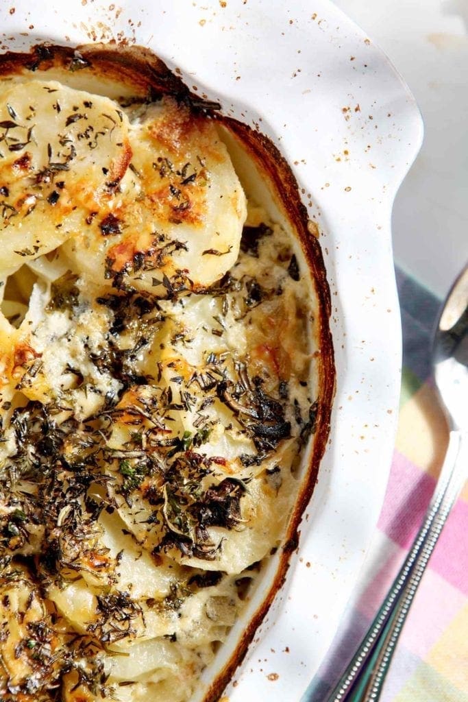 scalloped potatoes in a white baking dish