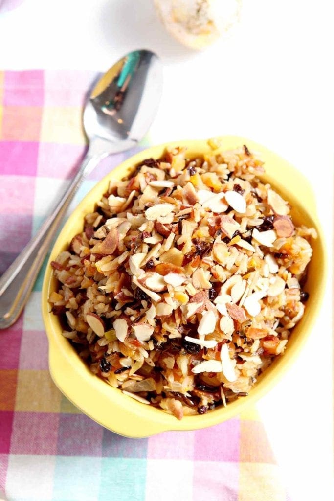 wild rice salad in a yellow bowl with a spoon