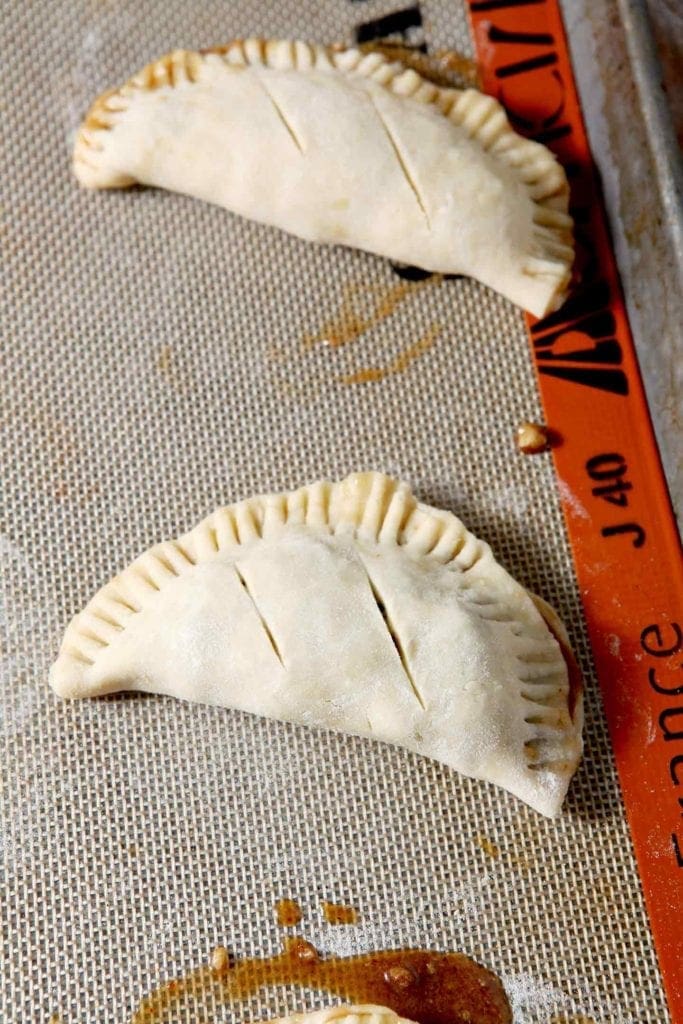 Unbaked Chocolate Bourbon Pecan Hand Pies on a baking sheet before they go into the oven