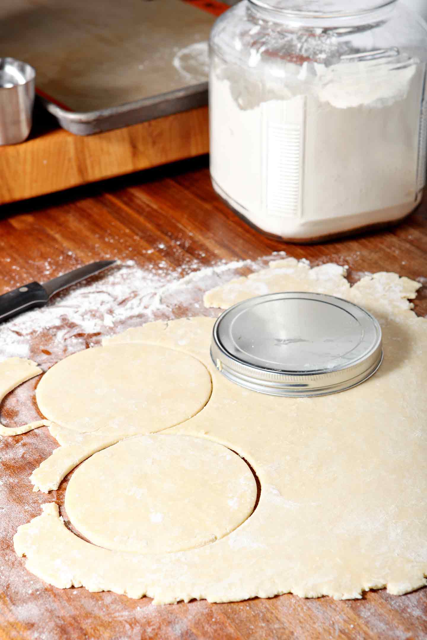 A canister lid is used to form the hand pie crust for Chocolate Bourbon Pecan Hand Pies before filling.