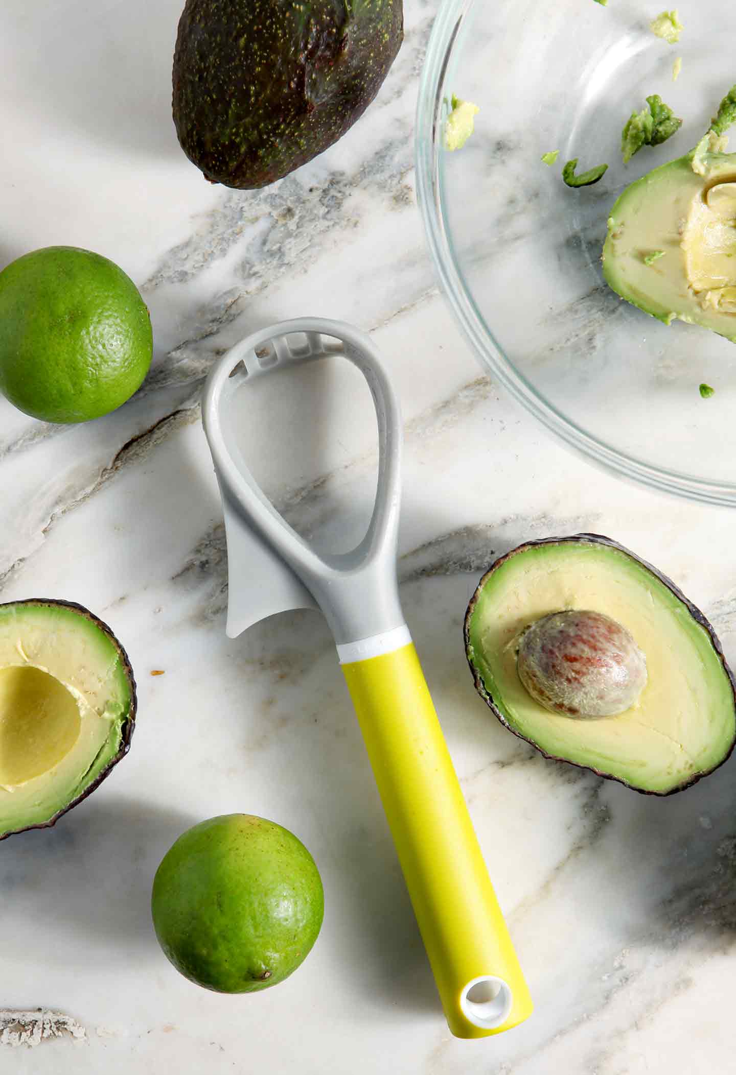 Avocados are shown with limes and the Casabella avocado slicer tool