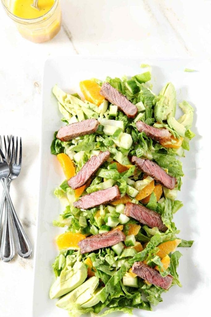 orange steak salad with 3 forks