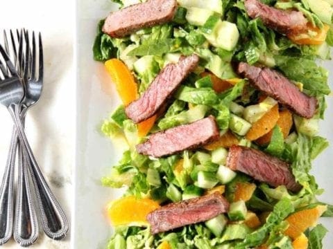 orange steak salad with 3 forks